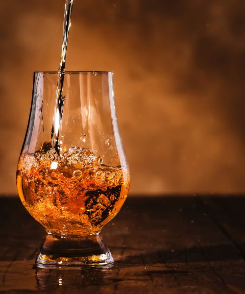 A glass of whiskey being poured at a Fordham Lee Distillery tasting event in New Windsor, MD.